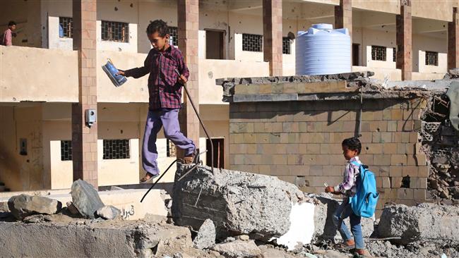 This file photo taken on March 16, 2017 shows Yemeni school children walking outside a school, that was damaged in Saudi air strike in the southern Yemeni city of Ta’izz. (By AFP)