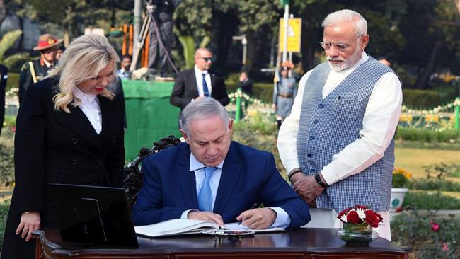 Israeli Prime Minister Benjamin Netanyahu is signing the visitors’ book as his wife Sara and Indian Prime Minister Narendra Modi look on, at the newly renamed Teen Murti Haifa Chowk in New Delhi on Jan. 14, 2018. (Photo by PTI)