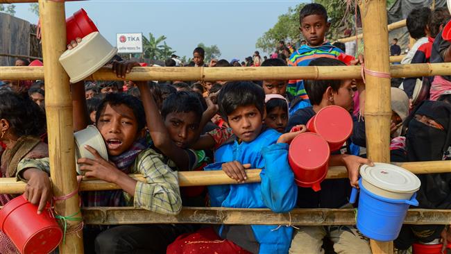 Rohingya Muslim refugees wait for food aid at the Thankhali refugee camp in Bangladesh. (Photo by AFP)