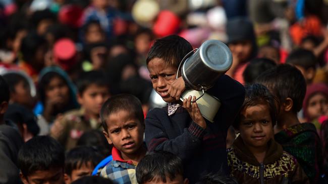 A Rohingya Muslim refugee waits with others for food aid at Thankhali refugee camp in Bangladesh