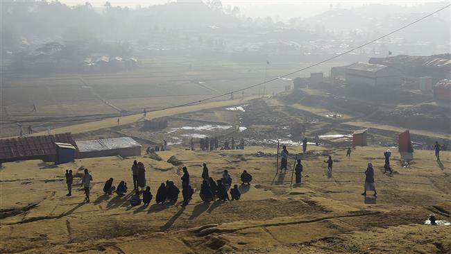 Rohingya refugee men sit together on a winter morning at Thankhali refugee camp in Bangladesh