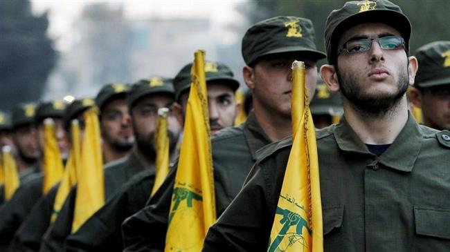 The file photo shows Hezbollah fighters holding flags of the Lebanese resistance movement during a parade in a southern suburb of Beirut, Lebanon. (AP photo)