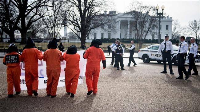 Members of the Secret Service surround activists as they protest the Guantanamo Bay detention camp on Pennsylvania Avenue outside the White House January 11, 2018 in Washington, DC. (Photo by AFP)