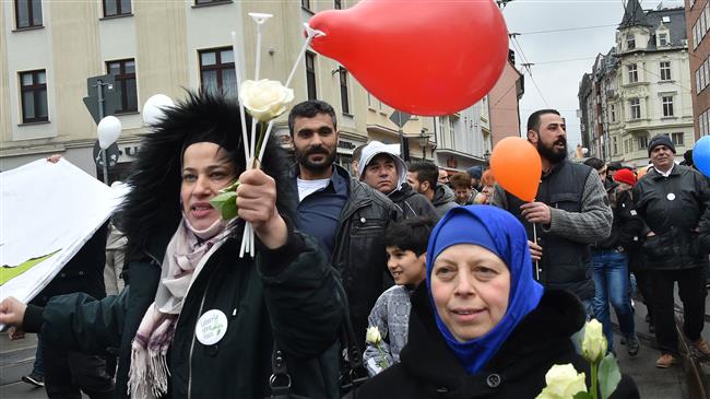 Women hold roses and balloons during a demonstration under the slogan “Live without hate,” in Cottbus, northeastern Germany, on February 3, 2018. (Photo by AFP)