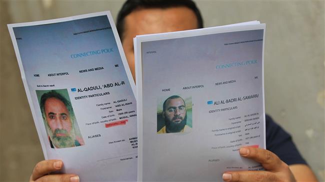 An Iraqi man holds printed profiles of Abu Bakr al-Baghdadi (R) and his deputy Abd al-Rahman al-Qaduli released by Iraqi authorities on February 6, 2018. (Photo by AFP)