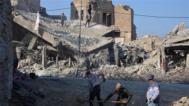 This picture taken on December 16, 2017 shows Iraqi volunteers salvaging and cleaning up the debris and destruction in the Bab al-Saray area in the old city of the northern Iraqi city of Mosul. (By AFP)