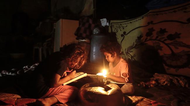 Palestinian children do their homework during a power cut in Gaza City, on September 11, 2017. (Photo by AFP)