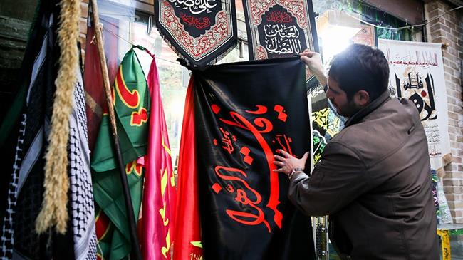 An Iranian man installs flags to mark the martyrdom anniversary of Hazrat Fatima Zahra (PBUH) on February 19, 2018. (Photo by Fars news agency)