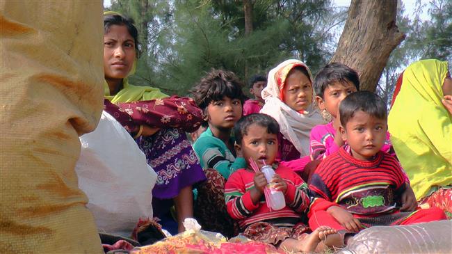 The photo, taken on February 22, 2018, shows newly arrived Rohingya Muslim refugees resting on the roadside in Teknaf after fleeing to Bangladesh from Myanmar. (Photo by AFP)
