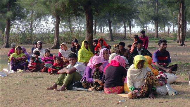 This photo taken on February 22, 2018, shows newly-arrived Rohingya refugees resting on the roadside in Teknaf after fleeing to Bangladesh from Myanmar. (Photo by AFP)