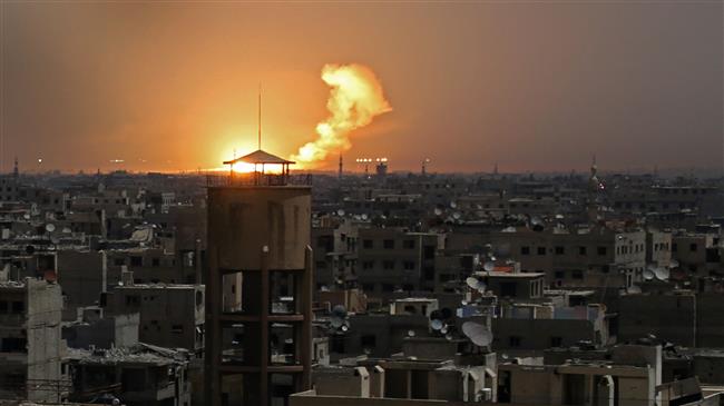 A picture taken on February 28, 2018 shows flames erupting in the horizon following a reported rocket attack in Eastern Ghouta suburb of the Syrian capital Damascus. (By AFP)