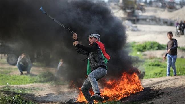 A Palestinian protester hurls a stone at Israeli soldiers during clashes with Israeli troops near the border between Israel and east Gaza Strip, on March 2, 2018. (Photo by Xinhua news agency)