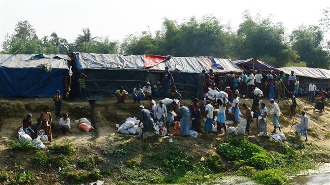 Rohingya Muslim refugees collect relief material next to a settlement near the