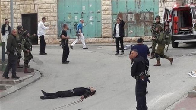 Palestinian Abdel Fattah al-Sharif lies on the ground following a fatal shooting in the occupied southern West Bank city of al-Khalil (Hebron) on March 24, 2016. (Photo by Ma’an news agency)