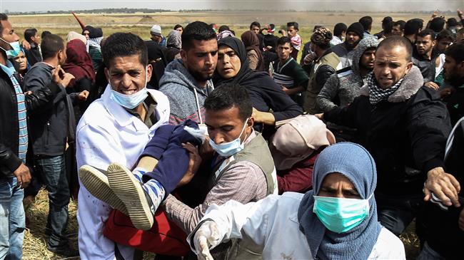 An injured Palestinian woman is carried by protesters as they run for cover during clashes with Israeli forces, east of teh city of Khan Yunis, in the southern Gaza Strip on March 30, 2018. (Photo by AFP)
