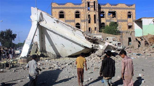 Children look at destruction in a petrol station following a Saudi airstrike on the outskirts of the city of Sa