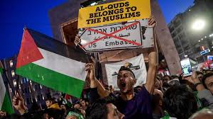 A protester holds a placard reading "Al-Quds (Jerusalem) belongs to the Muslims" as he shouts slogans among people holding Palestinian flags while they all take part in a protest march at the Istikilal avenue in Istanbul on May 14, 2018 (Photo by AFP)