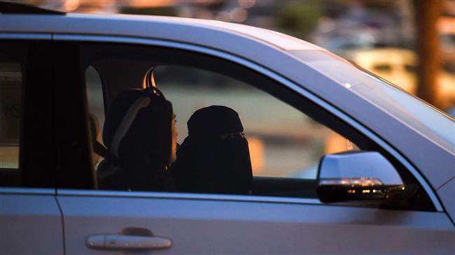 A Saudi woman (C) sits in the driver