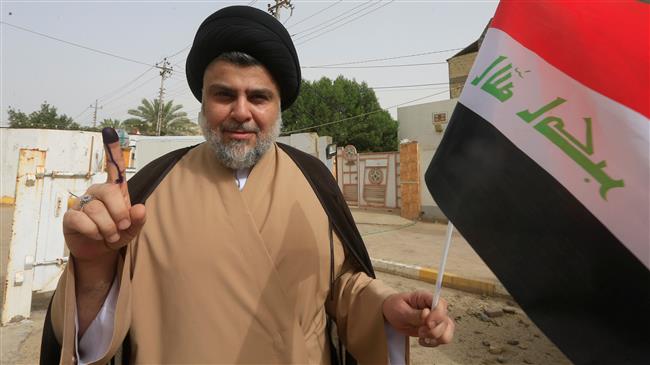 Iraqi Shia cleric Muqtada al-Sadr shows his ink-stained finger after casting his vote at a polling station during the parliamentary elections in Najaf, Iraq, May 12, 2018. (Photo by Reuters)