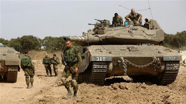 Israeli soldiers stand guard with their tank along the border between the occupied territories and the Gaza Strip on May 4, 2016. (Photo by AFP)