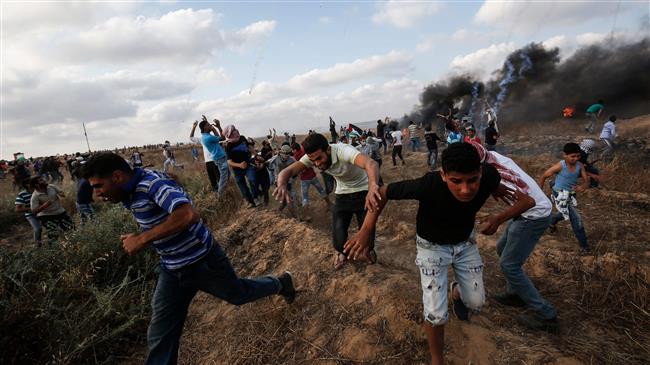 Palestinian protesters flee from incoming tear gas canisters during clashes following a demonstration along the border with occupied territories east of Khan Yunis in the southern Gaza Strip on June 1, 2018. (Photo by AFP)