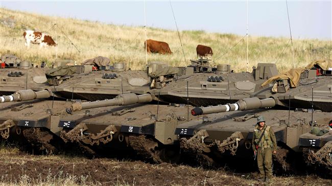 Merkava Mark IV tanks are deployed next to cows near the Syrian border in the Israel-occupied Golan Heights on May 10, 2018. (Photo by AFP)