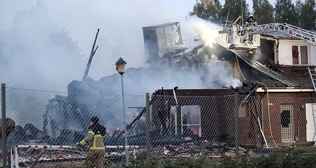 Firefighter stands in front of the smoldering ruins of a mosque building set on fire in the early hours of the morning on Sept. 26, 2017 in Orebro, Sweden. (EPA Photo)