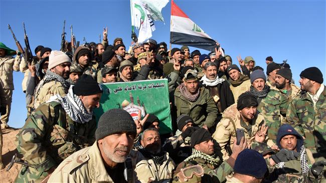 Members of one of the groups fighting within the Popular Mobilization Units (Hashd al-Sha’abi) celebrate after Iraqi Prime Minister Haider al-Abadi declared victory in the war against Daesh, in a location about 80 kilometers along the Iraqi-Syrian border west of the border town of al-Qa’im on December 9, 2017. (Photo by AFP)