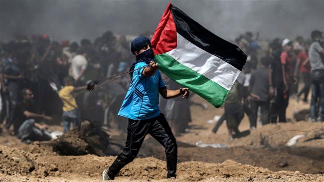 A Palestinian protester waves his national flag during a demonstration along the border with the Israeli-occupied territories east of Jabalia in the central Gaza Strip on June 8, 2018. (Photo by AFP)