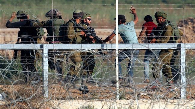 Israeli soldiers arrest the Palestinians who tried to approach the Gaza fence during clashes east of Gaza City on May 15, 2018. (Photo by AFP)