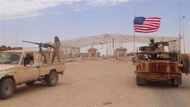 In this file picture, a US-backed Takfiri militant mans a heavy automatic machine gun (L) next to an American soldier as they take their positions at the al-Tanf border crossing between Syria and Iraq.