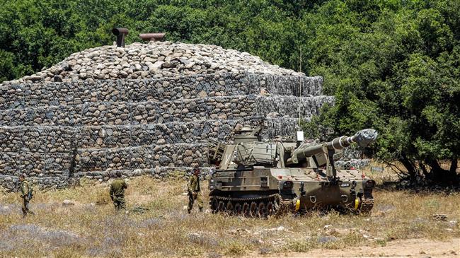 Israeli soldiers walk past a bunker with a mobile artillery piece near the Syrian border in the Israeli-held Syrian Golan Heights, July 1, 2018. (Photo by AFP)