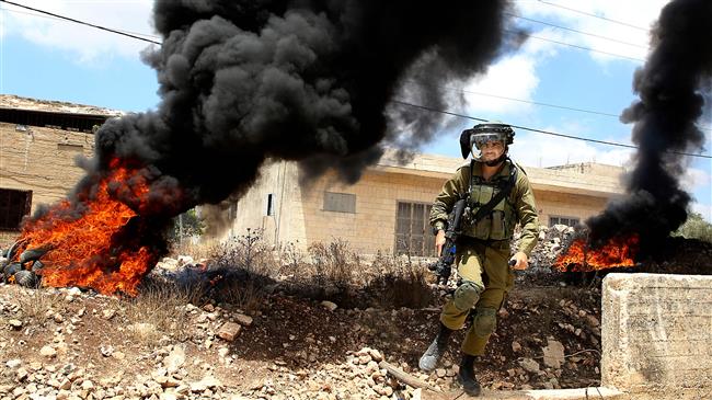 An Israeli soldier takes position against Palestinian protesters following a weekly demonstration against the expropriation of their land in the village of Kfar Qaddum, near Nablus in the occupied West Bank, on June 29, 2018. (Photo by AFP)