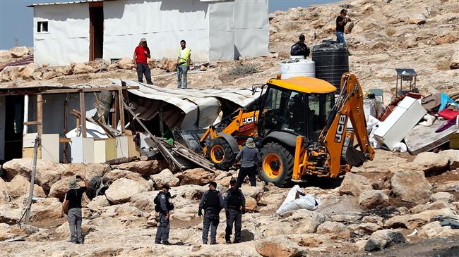 Israeli police officers secure a bulldozer demolishing structures in the Palestinian Bedouin village of Khan al-Ahmar, east of Jerusalem in the occupied West Bank on July 4, 2018. (Photo by AFP)