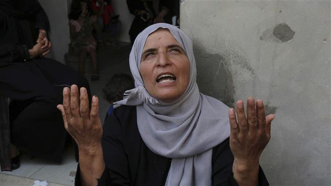 The mother of Mohammed Ghassan Abu Daqqa, a Palestinian shot by Israeli forces during border protests east of Khan Yunis on May 14, lifts up her hands in prayer as she mourns during his funeral after he succumbed to his wounds on June 21, 2018. (Photo by AFP)
