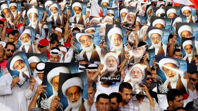 Anti-government protesters hold posters of Shia cleric Sheikh Isa Qassim in Budaiya, Bahrain, in 2013. (Photo by Reuters)