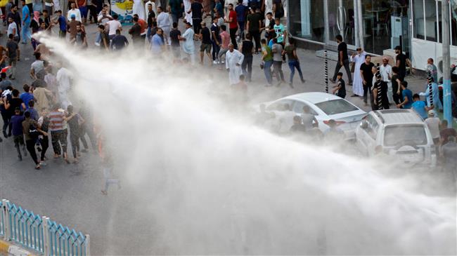 Demonstrators are sprayed by water cannon employed by the Iraqi security forces during protests in the central shrine city of Najaf, Iraq, on July 14, 2018. (Photo by AFP)
