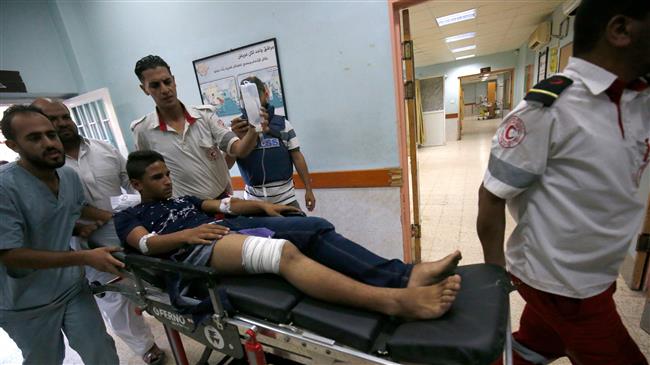 Palestinian paramedics push a youth, who was injured during Israeli bombardment, as he lies on a gurney into a hospital in Khan Yunis in the southern Gaza Strip on July 20, 2018. (Photo by AFP)