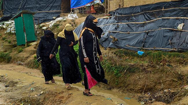 Rohingya refugee women make their way as rain falls at the Jamtoli refugee camp in Ukhia, Bangladesh, on July 20, 2018. (Photo by AFP)
