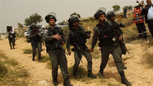 Israeli forces stand guard near the separation fence between the city of Bethlehem and Jerusalem al-Quds in the occupied West Bank on May 10, 2018. (Photo by AFP)