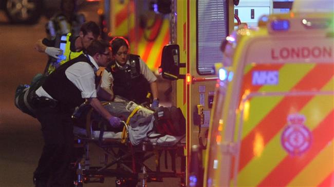 In this file photo taken on June 04, 2017 Police officers and members of the emergency services attend to a person injured in an apparent terror attack on London Bridge in central London on June 3, 2017. (AFP photo)