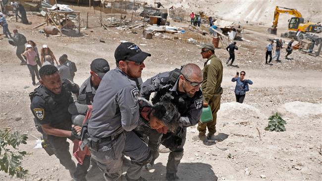 Israeli forces arrest a young demonstrator protesting against demolitions in the Palestinian Bedouin village of Khan al-Ahmar, east of Jerusalem al-Quds, occupied West Bank on July 4, 2018. (Photo by AFP)