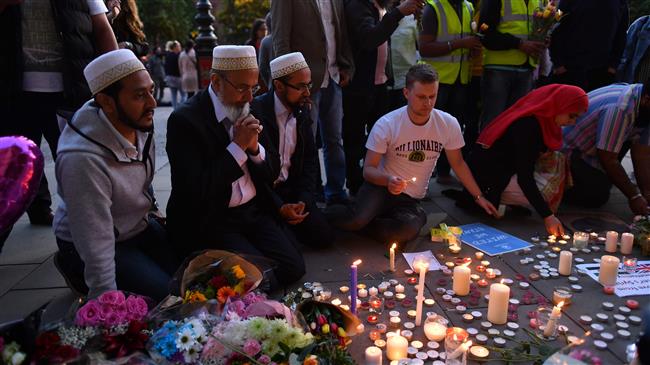 In this file photo taken on May 23, 2017 people pray and light candles set up in front of floral tributes in Albert Square in Manchester, northwest England on May 23, 2017, in solidarity with those killed and injured in the May 22 terror attack at the Ariana Grande concert at the Manchester Arena. (AFP photo)