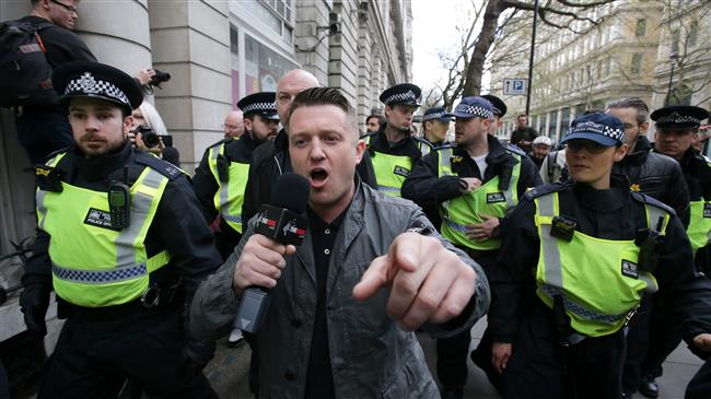 In this file photo taken on April 01, 2017 Stephen Christopher Yaxley-Lennon, AKA Tommy Robinson, former leader of the right-wing EDL (English Defence League) is escorted away by police from a Britain First march and an EDL march in central London on April 4, 2017. (AFP photo)