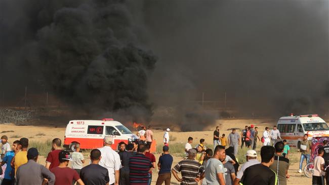 Palestinian protesters gather as black smoke rises from burning tires during a demonstration near the Gaza fence, in Khan Yunis in the southern Gaza Strip on August 3, 2018. (Photo by AFP)