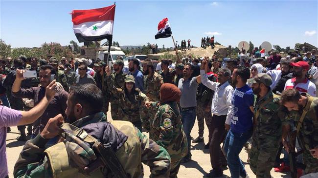 Syrian soldiers and civilians celebrate the return of government authority to the town of Quneitra adjacent to Israeli-occupied Golan Heights on July 27, 2018. (Photo by AP)