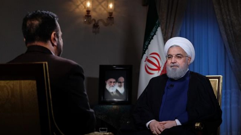 Iranian President Hassan Rouhani (R) speaks in a live televised interview in Tehran on August 6, 2018.