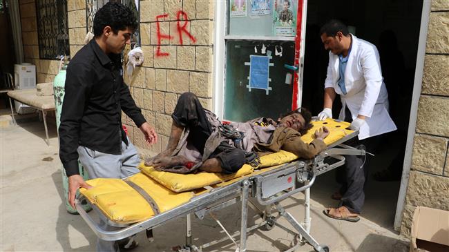 A doctor attends to a boy injured by a Saudi airstrike in Sa