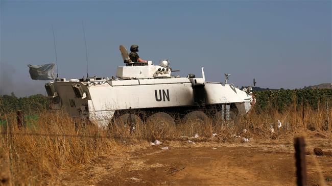 A peacekeeper from the UN Disengagement Observer Force (UNDOF) stationed in the Israeli-occupied Golan Heights sits in an infantry fighting vehicle while on patrol near the Quneitra crossing checkpoint on July 20, 2018. (Photo by AFP)