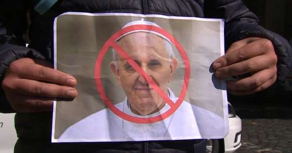 Protesters holding baby shoes and rainbow flags greet Pope Francis in Ireland